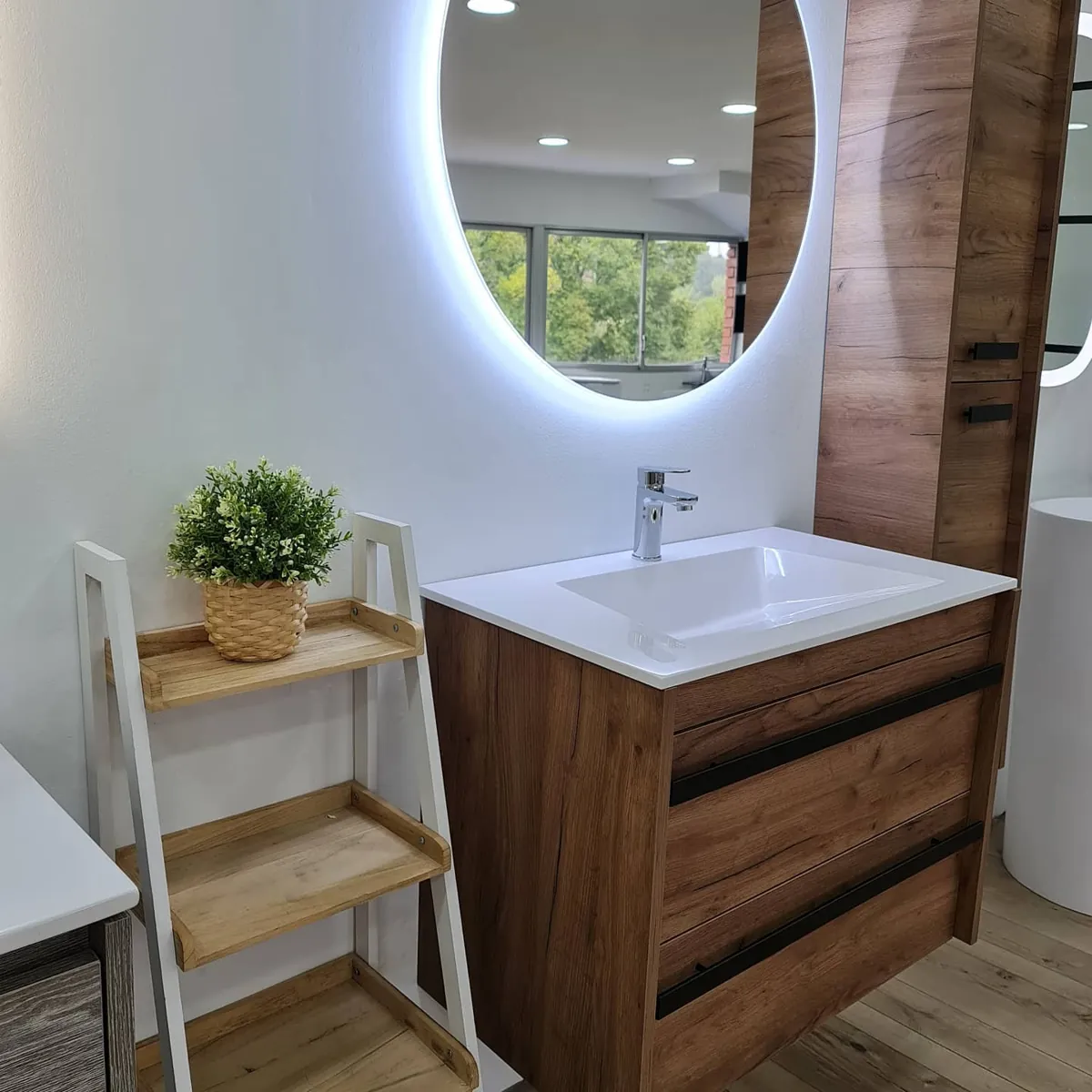 Lavabo sobre mueble de madera con espejo redondo iluminado