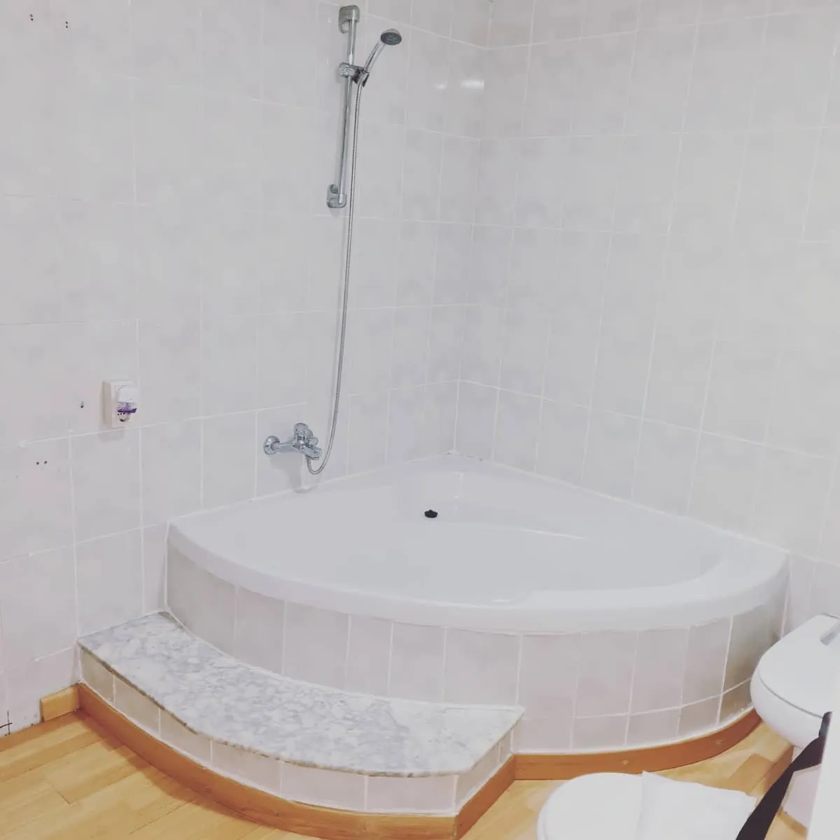 Antes: Baño reformado: ducha a nivel de suelo con mampara fija, suelo porcelánico efecto madera y mueble suspendido