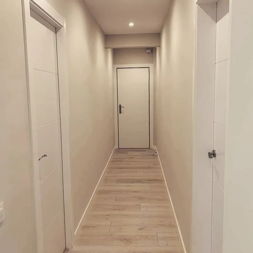 Passadís amb parquet i portes lacades en blanc